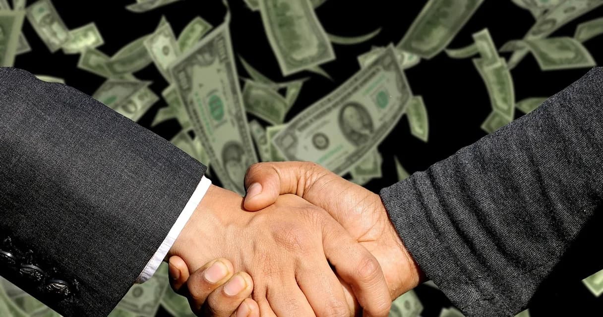 Aperto de mãos entre dois empresários fechando uma parceria