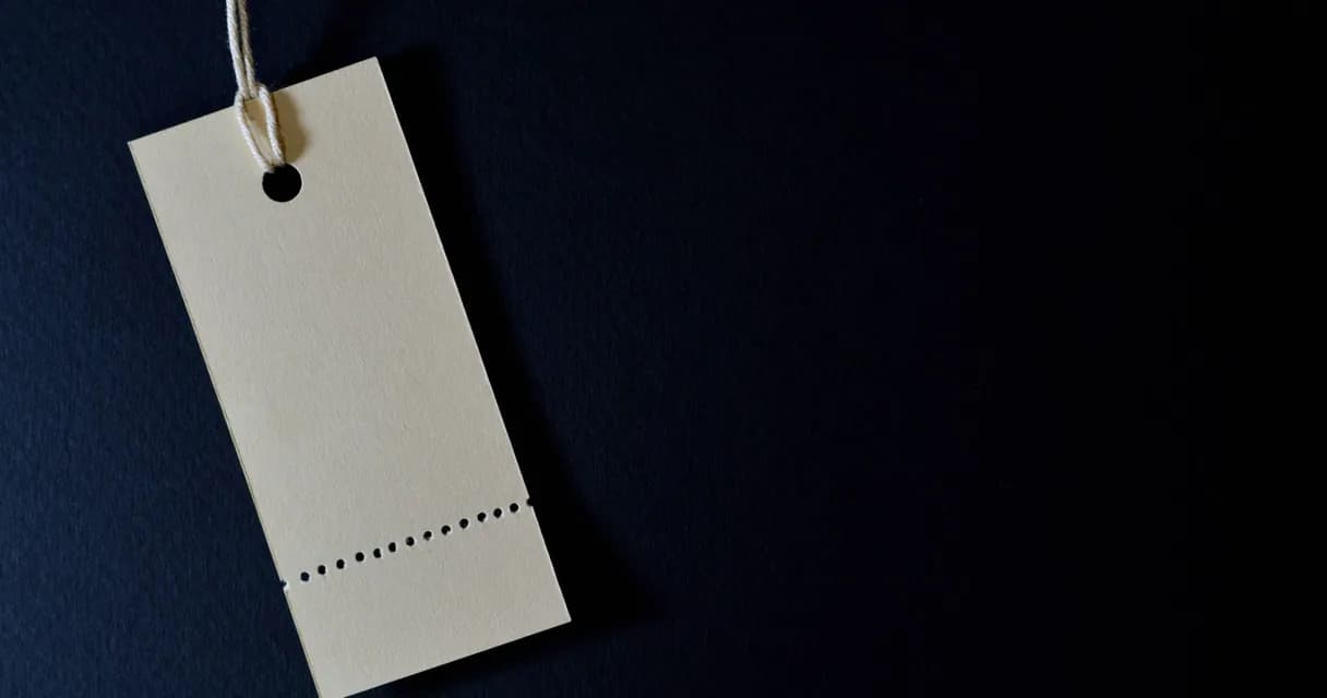 Etiqueta de preço em branco pendurada sobre fundo escuro
