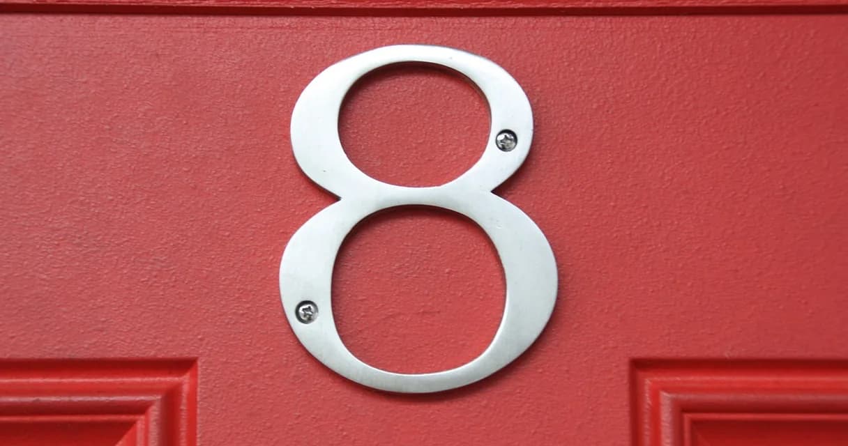 Domínio com palavra-chave: placa de endereço numerada presa em uma porta de madeira