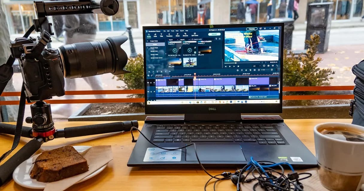 Câmera em tripé ao lado de um notebook com editor de vídeo