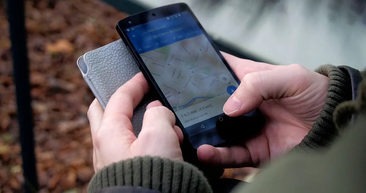 Posição no Google: mãos segurando um celular com um mapa de busca aberto na tela